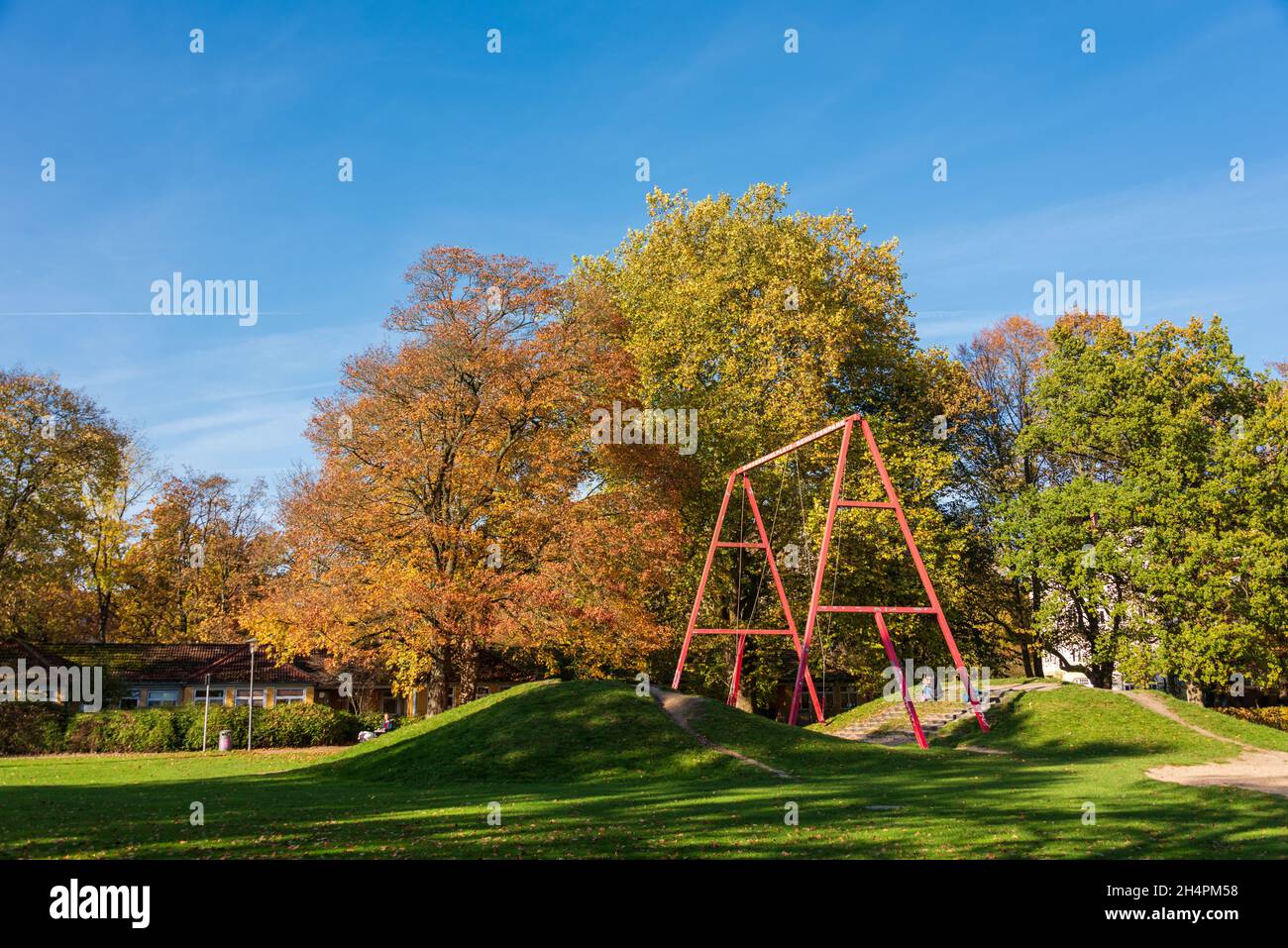 Kinderspielplatz in einem Stadtpark in Norddeutschland mit Bäumen im farbigen Herbstlaub Stock Photo