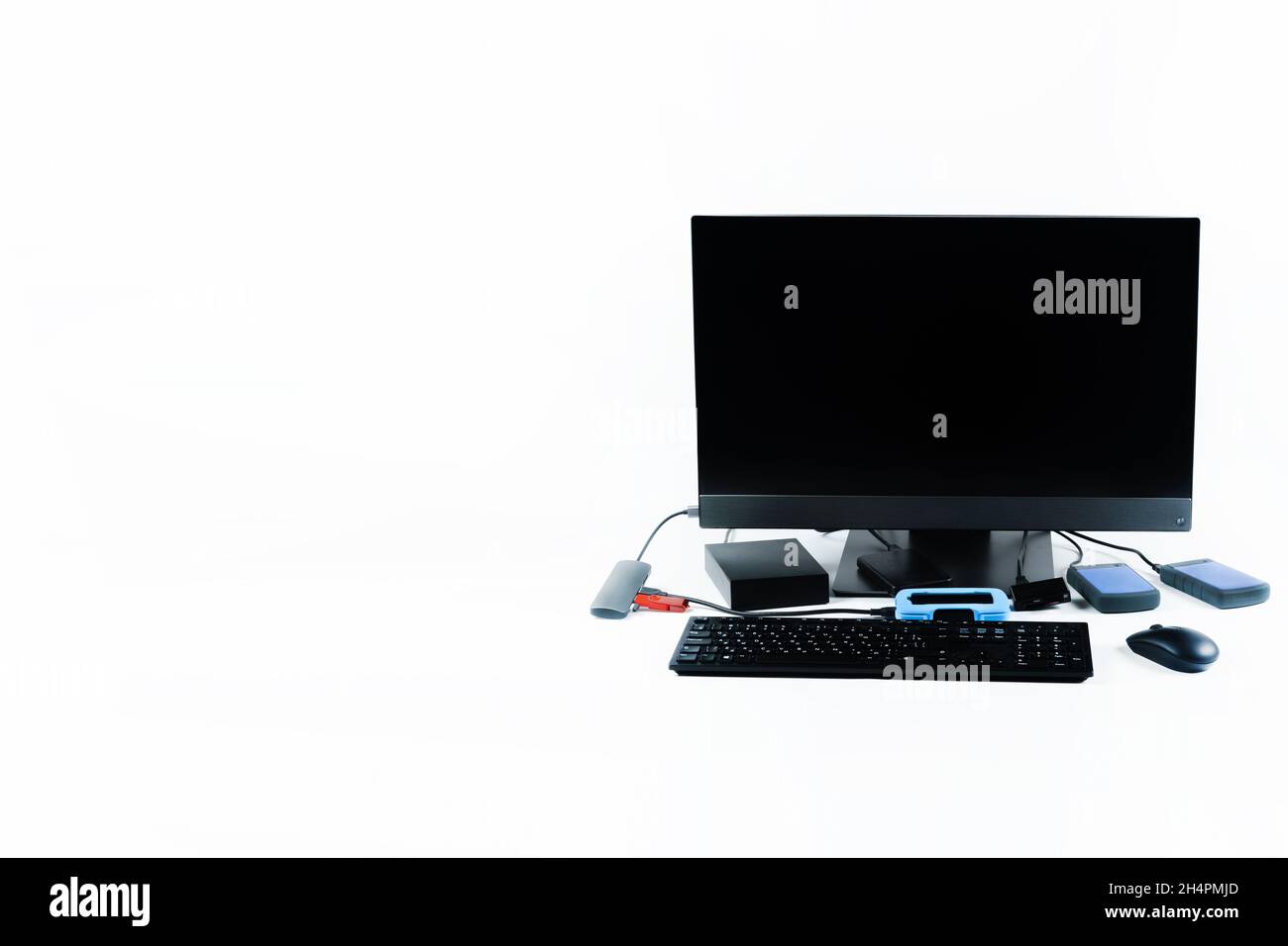 Multiple external hard drives connected to a monoblock on a white with hard