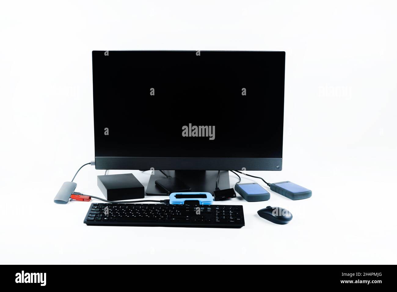 Multiple external hard drives connected to a monoblock on a white with hard