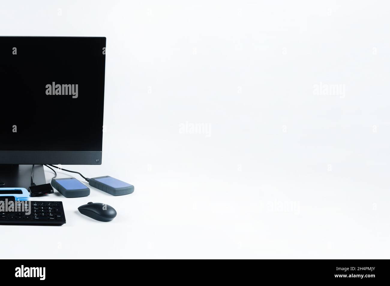 Multiple external hard drives connected to a monoblock on a white background.Computer with hard drive. Stock Photo