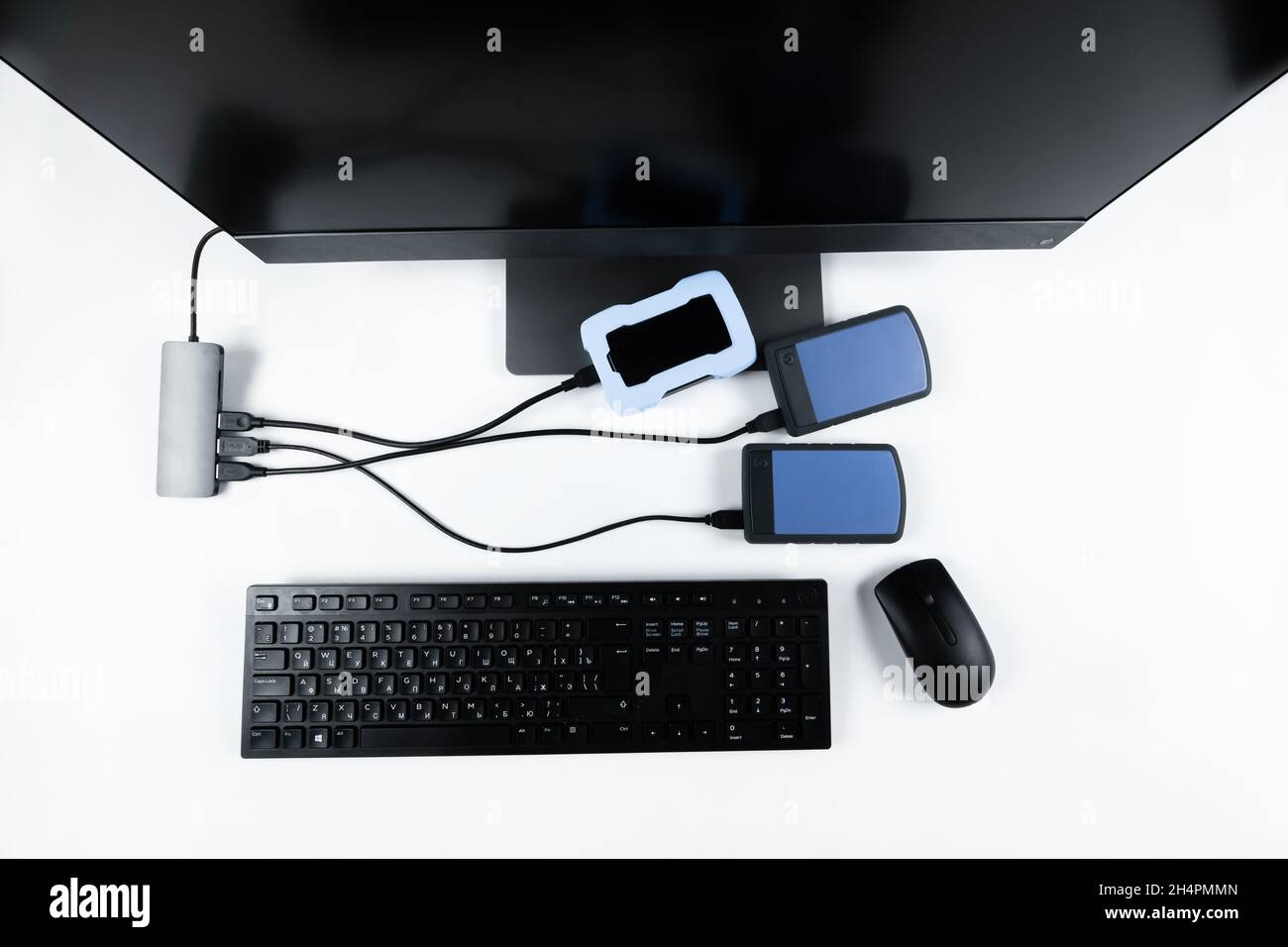 Multiple external hard drives connected to a monoblock on a white with hard