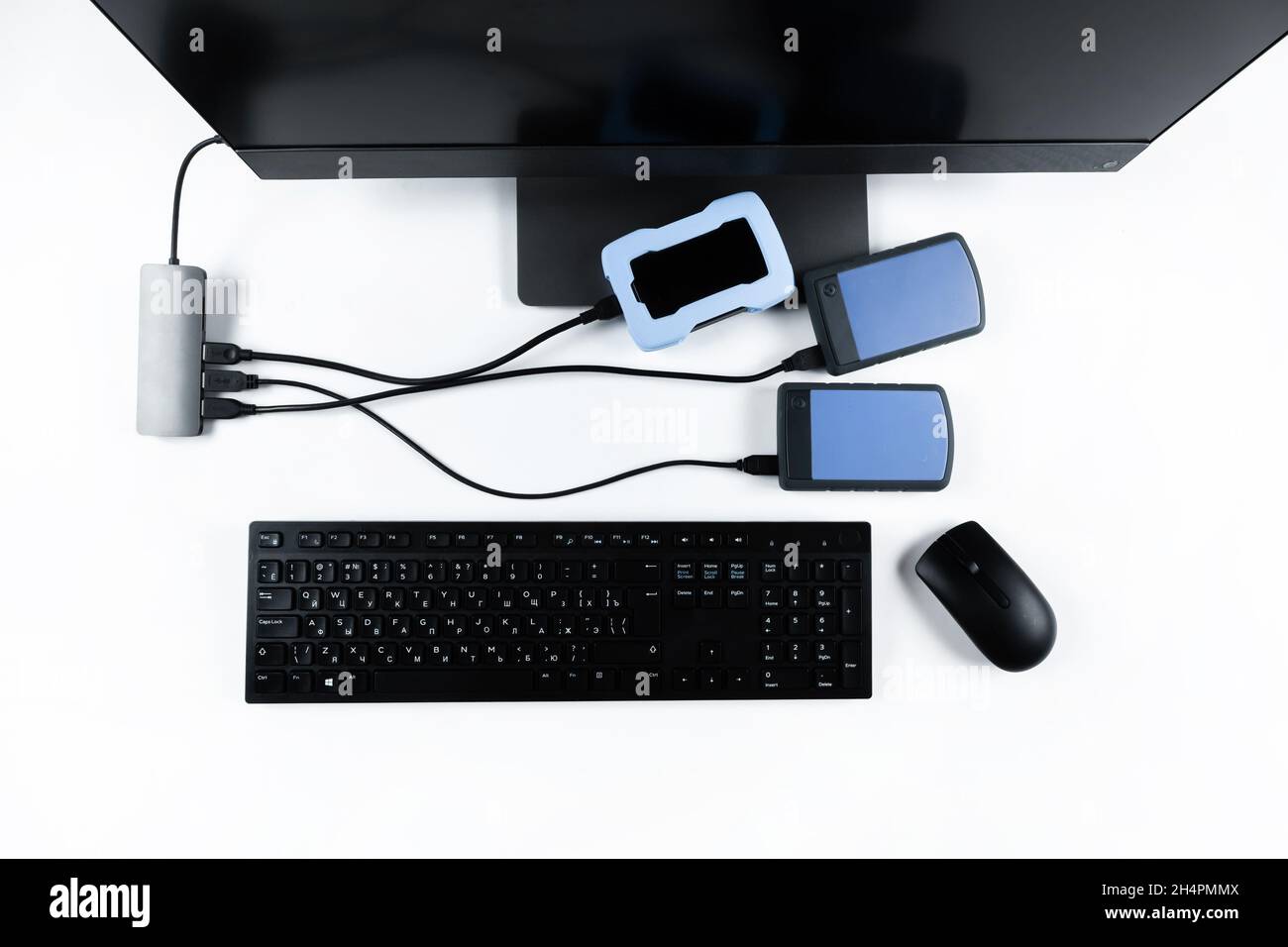 Multiple external hard drives connected to a monoblock on a white with hard