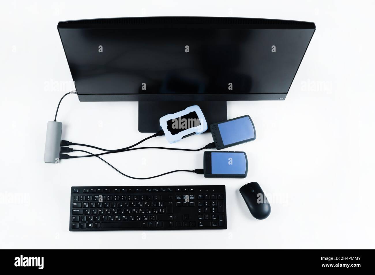 Multiple external hard drives connected to a monoblock on a white with hard