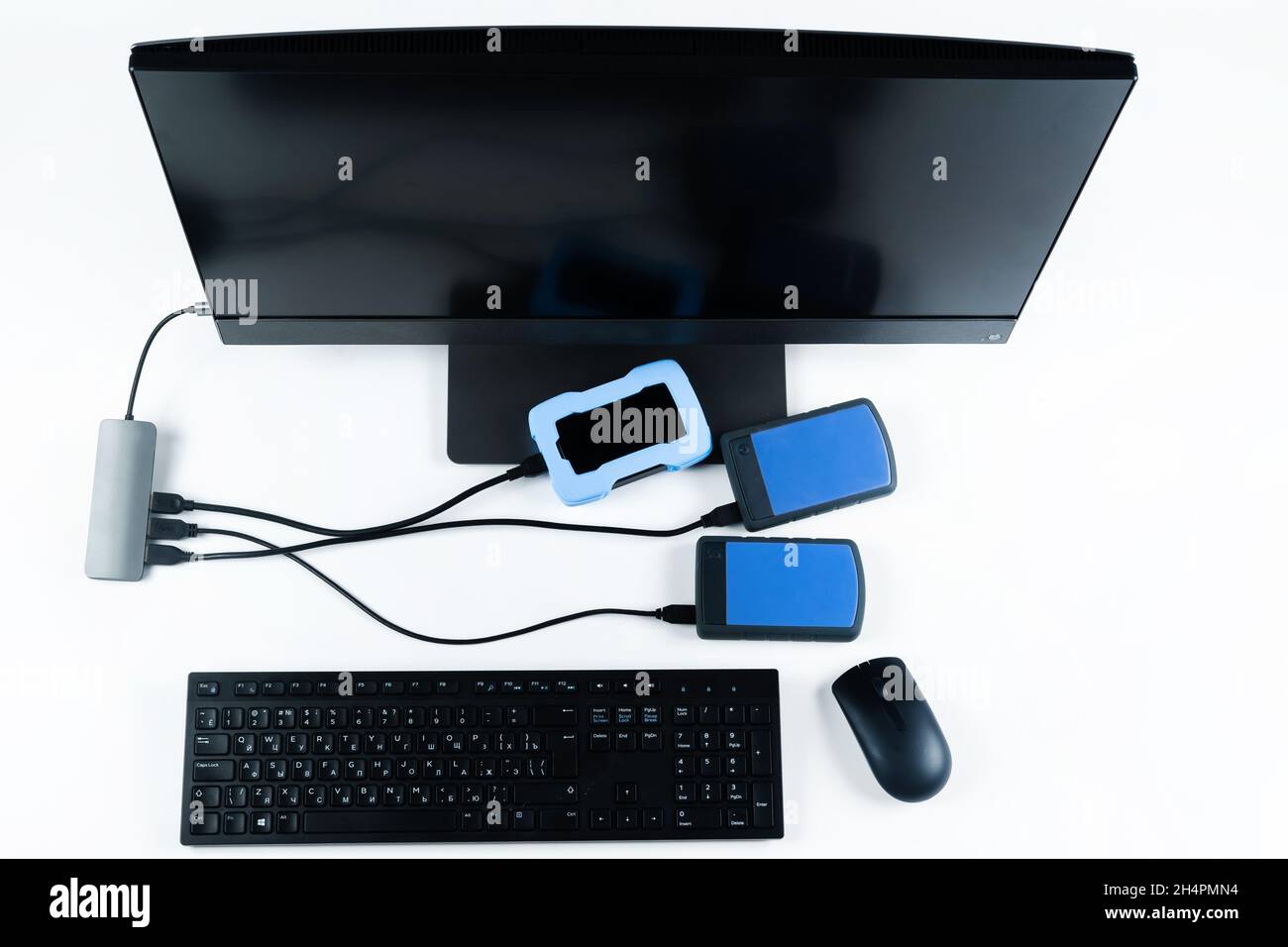 Multiple external hard drives connected to a monoblock on a white