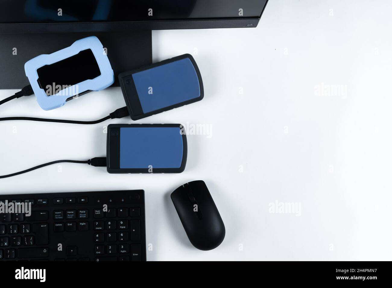 Multiple external hard drives connected to a monoblock on a white with hard