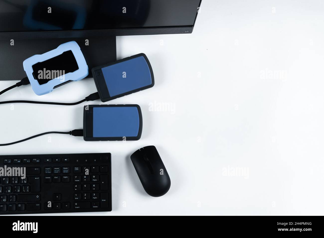 Multiple external hard drives connected to a monoblock on a white with hard