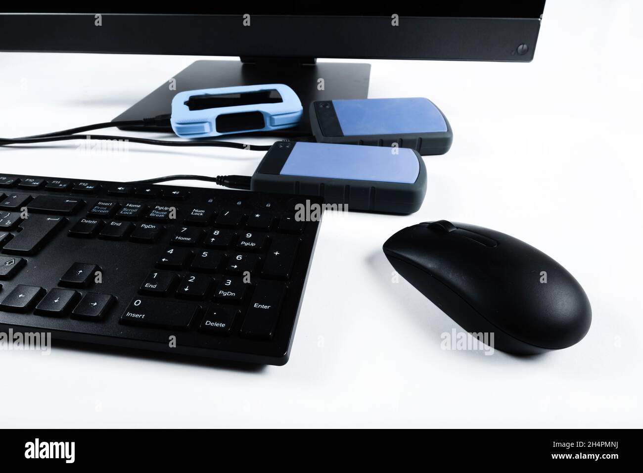 Multiple external hard drives connected to a monoblock on a white with hard