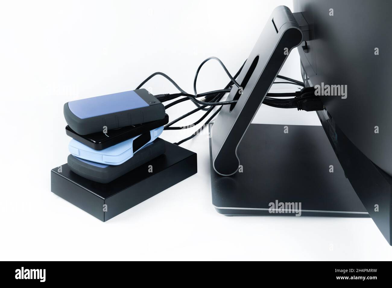 Multiple external hard drives connected to a monoblock on a white with hard