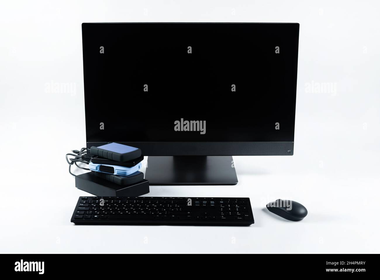 Multiple external hard drives connected to a monoblock on a white with hard