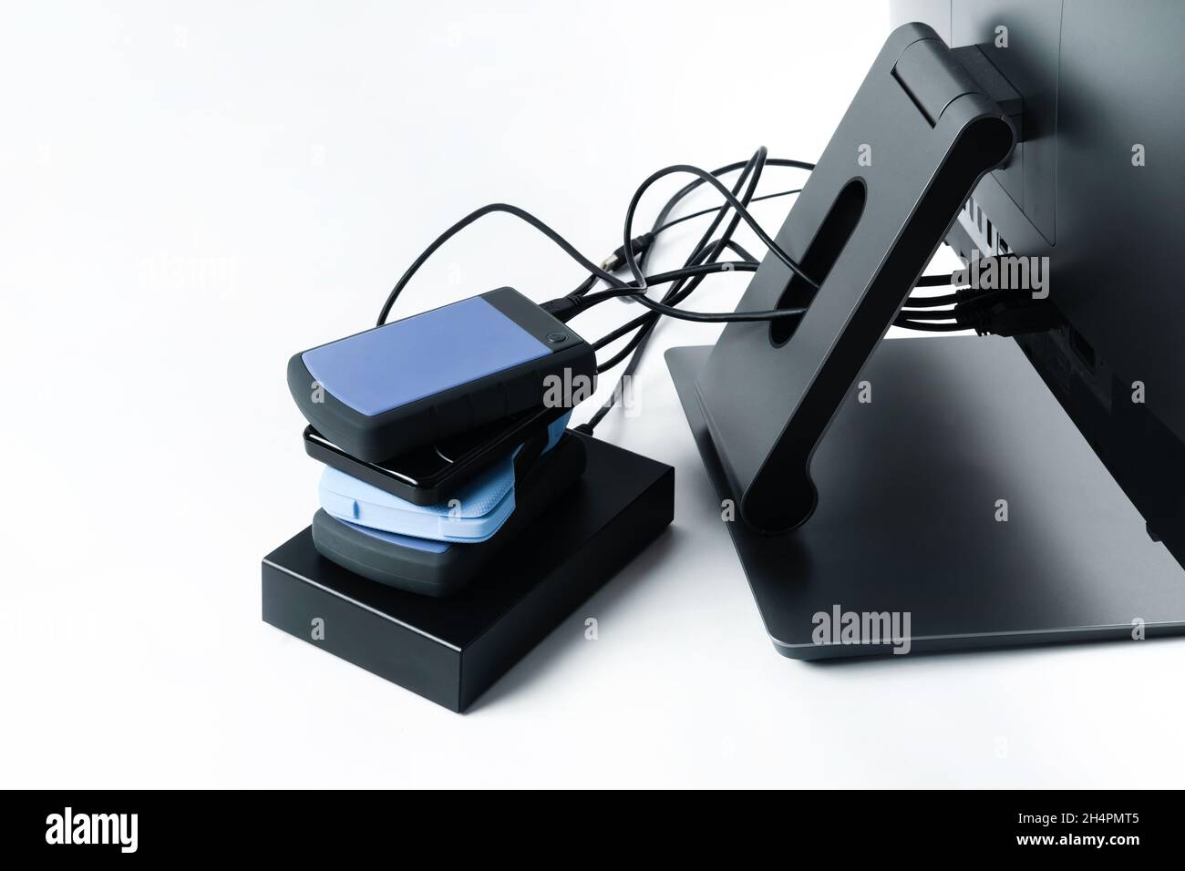 Multiple external hard drives connected to a monoblock on a white