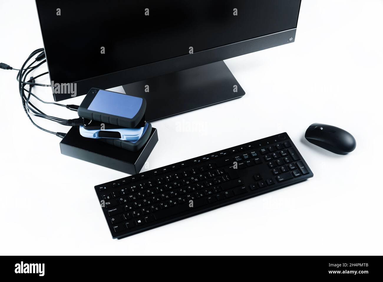 Multiple external hard drives connected to a monoblock on a white with hard