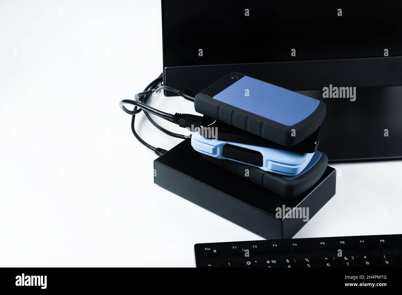 Multiple external hard drives connected to a monoblock on a white