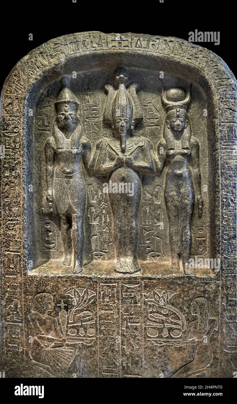 Ancient Egyptian stele of the patron gods of Abydos, Osiris, Horus and Isis, 1294-1279 BC, reign of Sethi 1st, 19th Dynasty, diorite. The Louvre Museu Stock Photo
