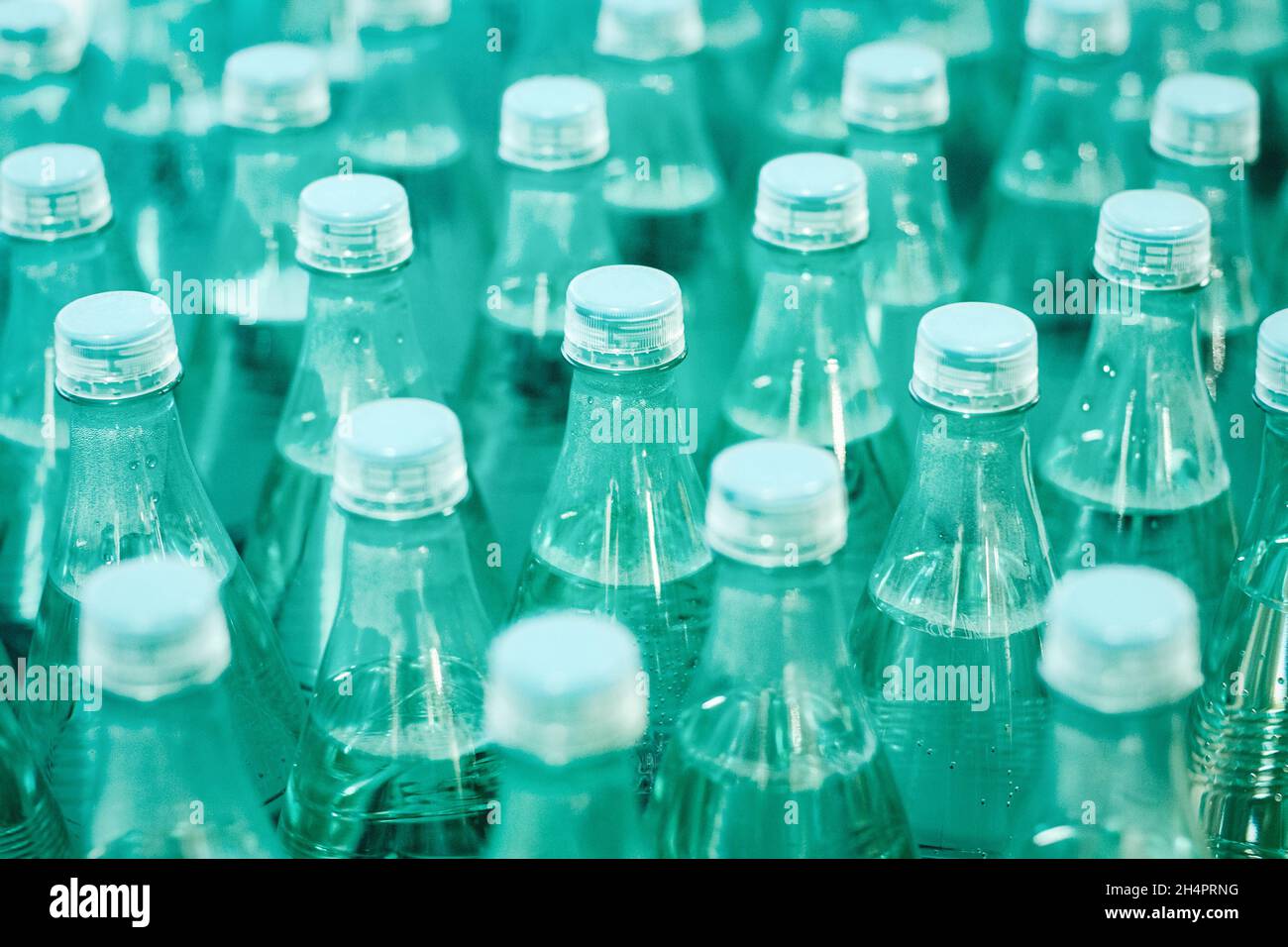 Mineral drinking water in green plastic bottles in the grocery store