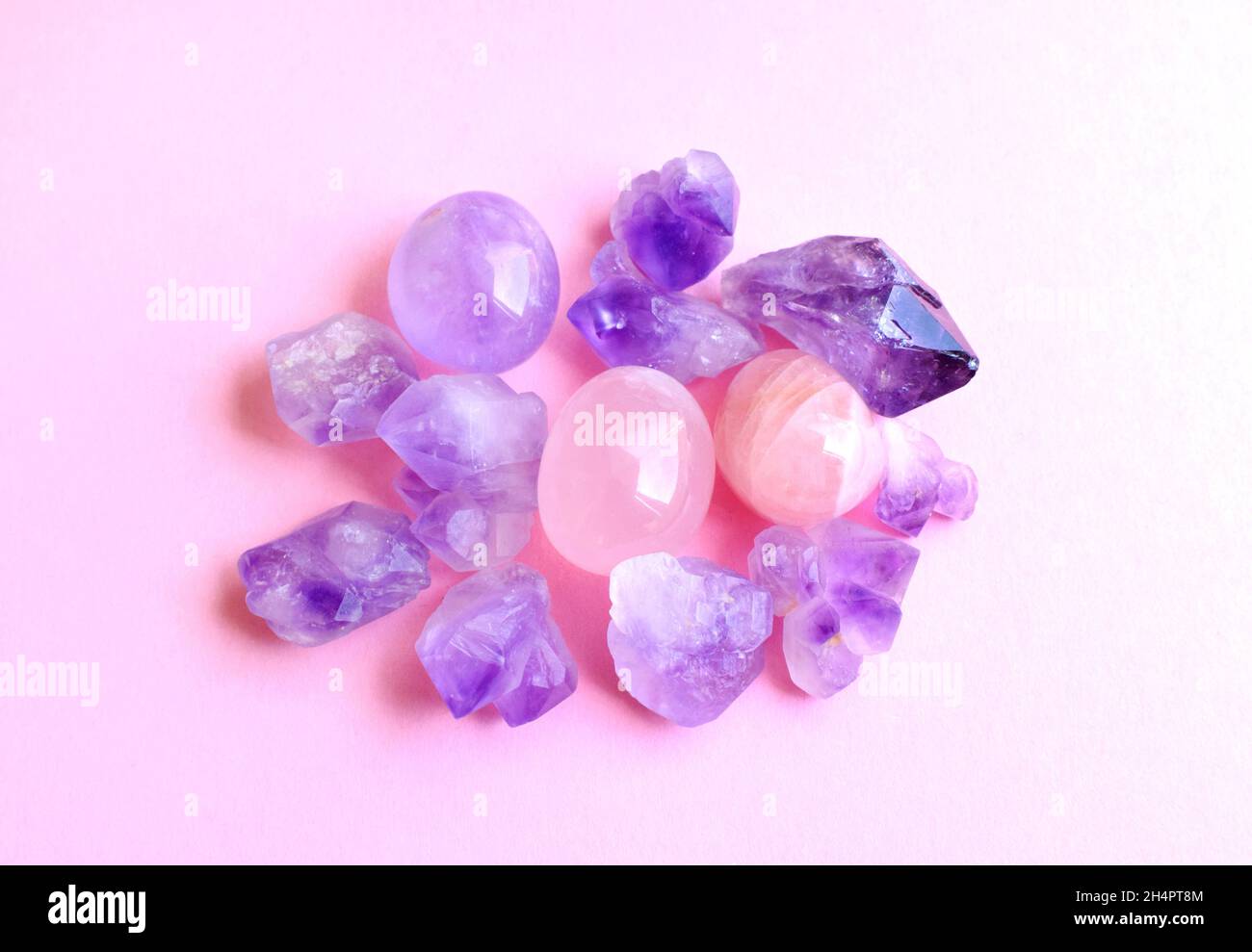 Minerals of gemstones on a pink background. Beautiful purple amethyst
