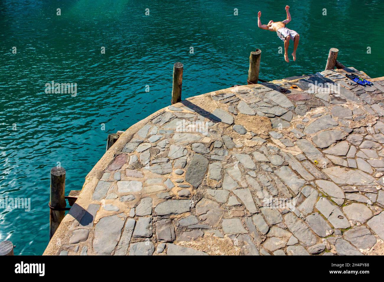 Man jumping into the sea at Clovelly a harbour village overlooking Bideford Bay and the Bristol Channel in North Devon England UK Stock Photo