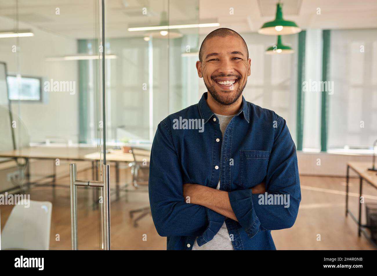 Young businessman laughing while standing in a modern office Stock Photo