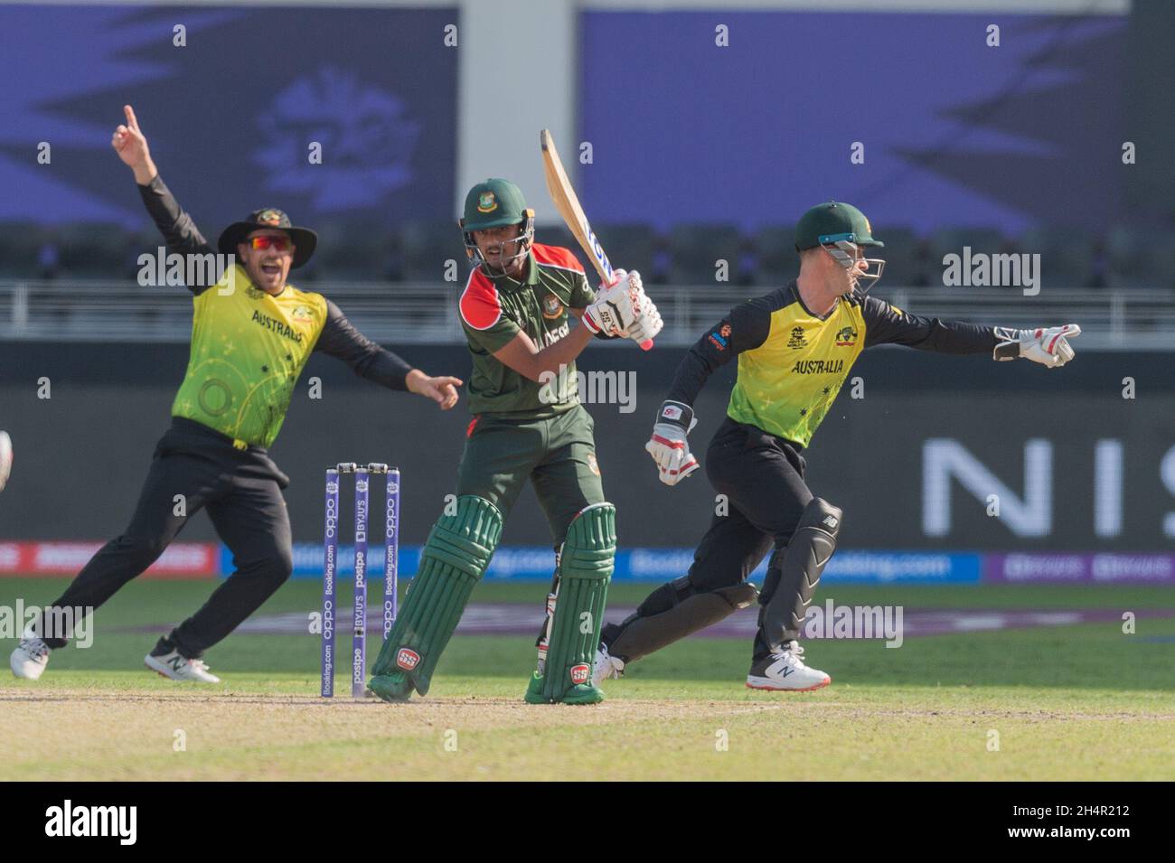 Dubai, UAE, 4th Nov, 2021. Mahedi Hasan of Bangladesh looks on in hope as Aaron Finch (left) and Matthew Wade of Australia celebrate during the ICC Mens T20 World Cup match between Australia and Bangladesh at Dubai International Cricket Stadium, Dubai, UAE on 04 November 2021. Photo by Grant Winter. Editorial use only, license required for commercial use. No use in betting, games or a single club/league/player publications. Credit: UK Sports Pics Ltd/Alamy Live News Stock Photo