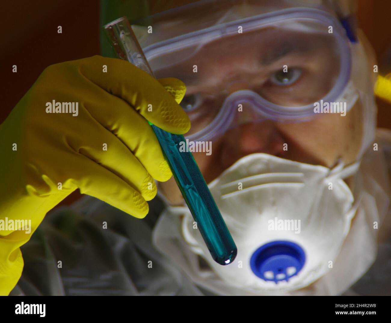 A scientist with a test tube in his hand is working on a new substance. Concept of pharmacy, research, biochemistry, microbiology, medicine, science, Stock Photo