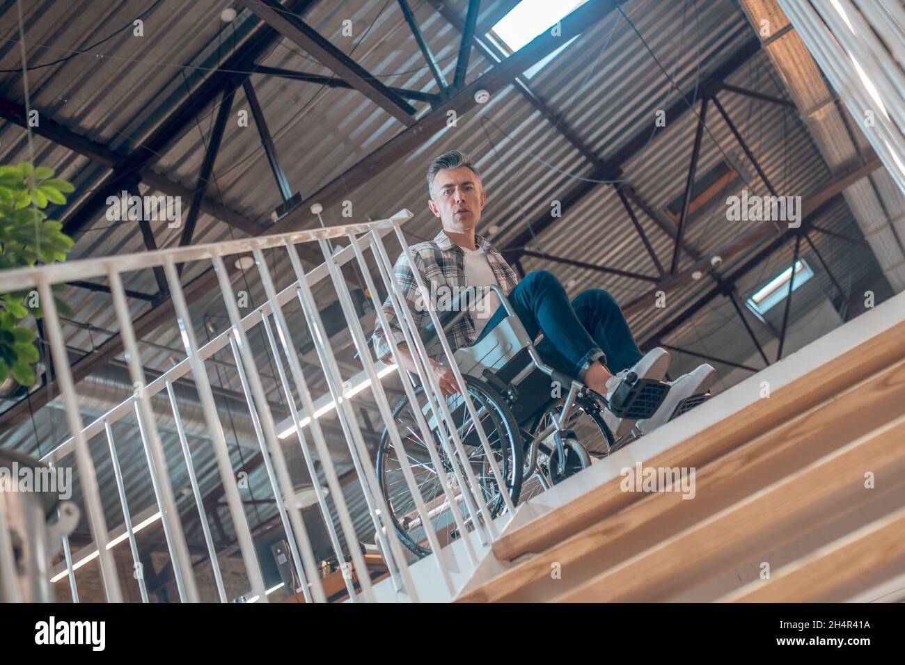 Low angle view of man in wheelchair near stairs down Stock Photo