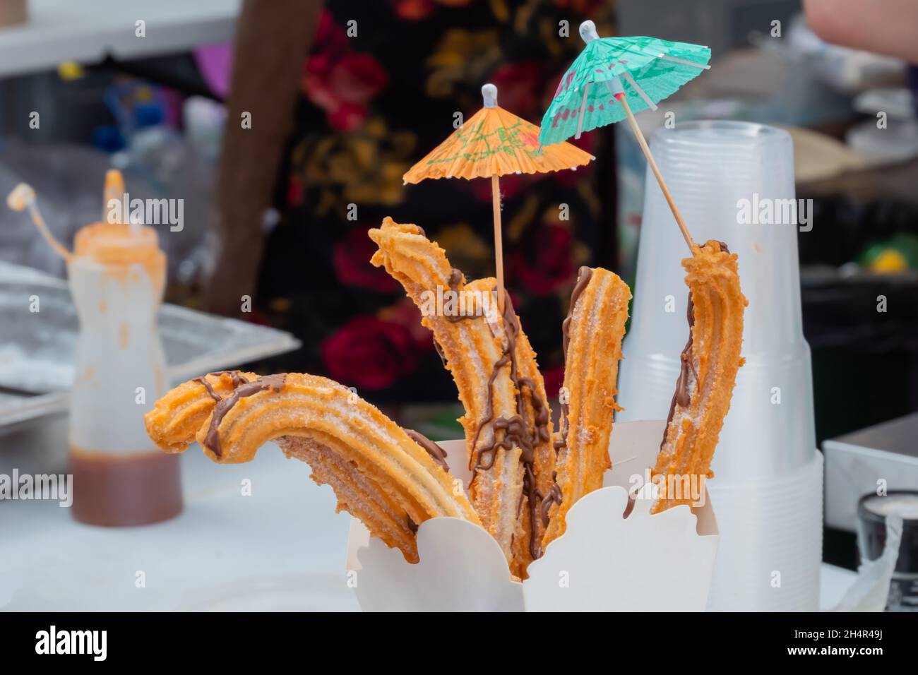 Homemade crunchy churros in paper box at street food market: close up Stock Photo