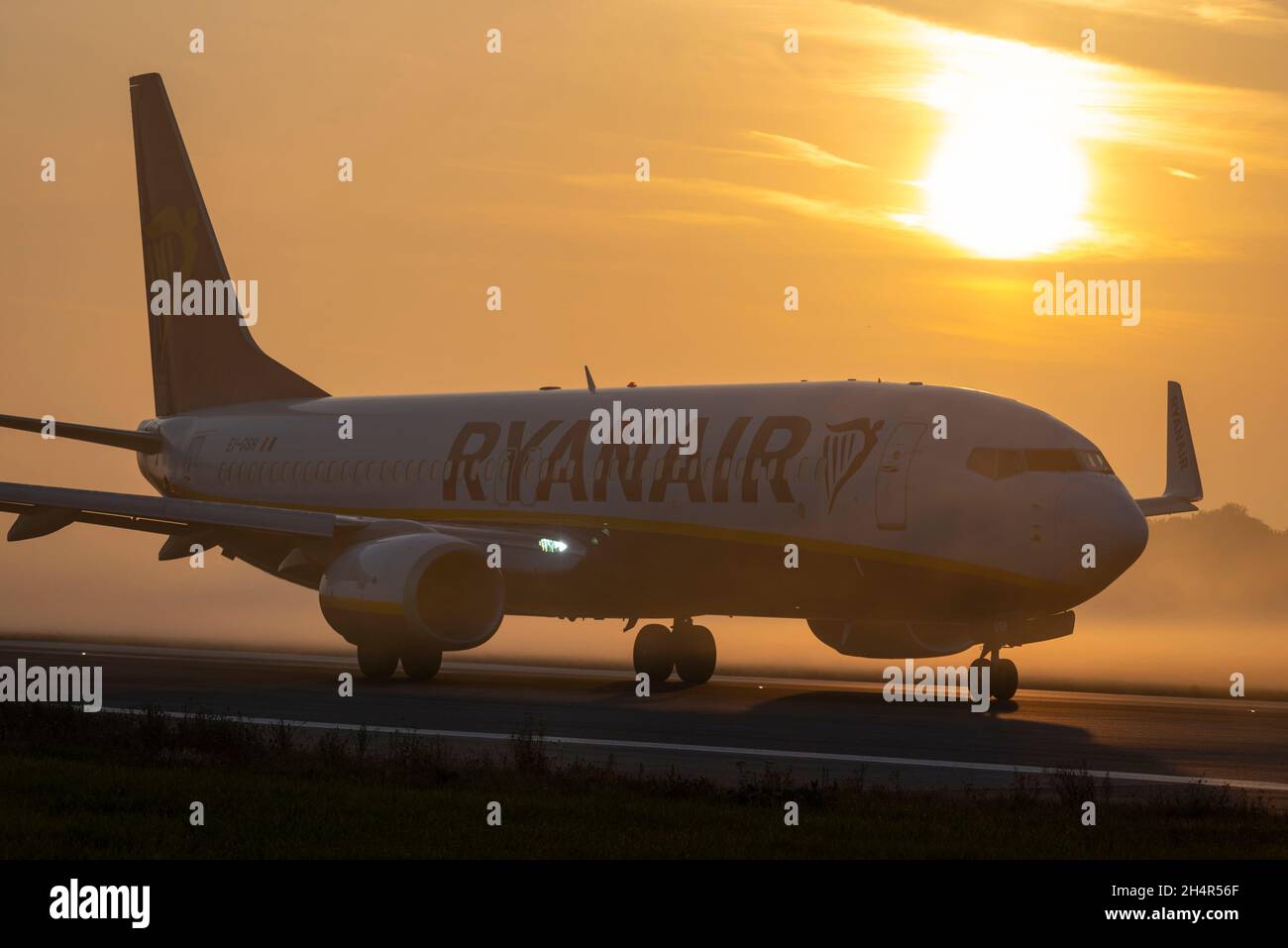 Ryanair Boeing 737 airliner jet plane taxiing out for an early morning flight at London Southend Airport, Essex, UK, in fog and mist at sunrise Stock Photo