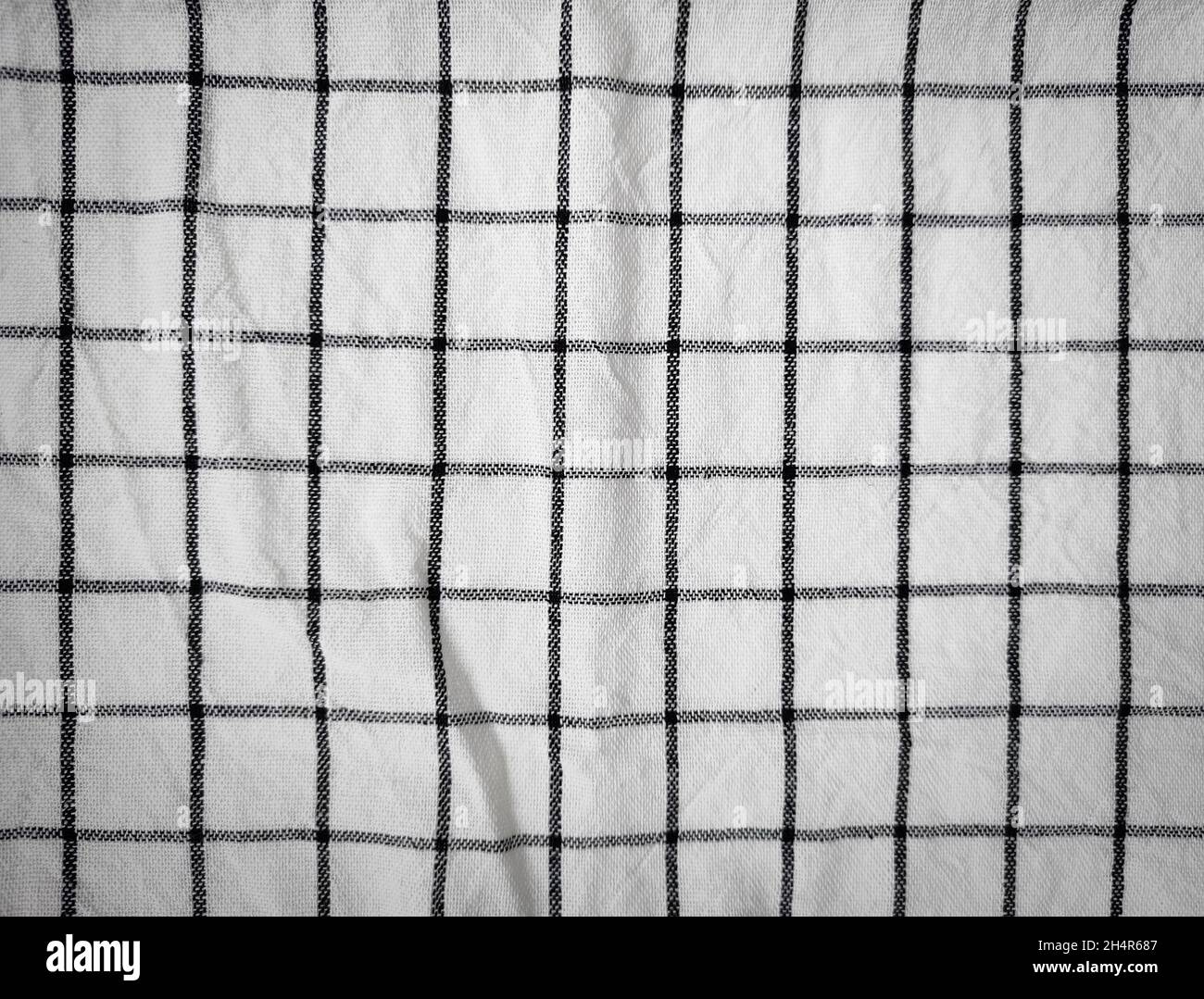 Checkered tablecloth fabric or towel. Black with white square pattern as background Stock Photo