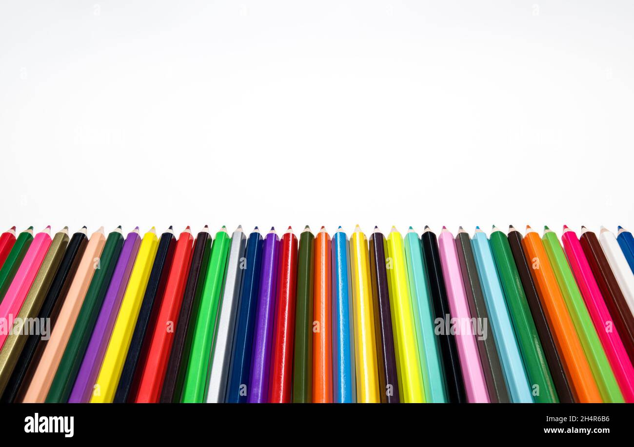 Creative back to school concept. Colored crayons against white background. Stock Photo