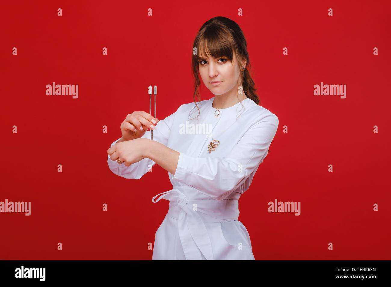 Beautiful girl doctor with a tuning fork stands Stock Photo Alamy