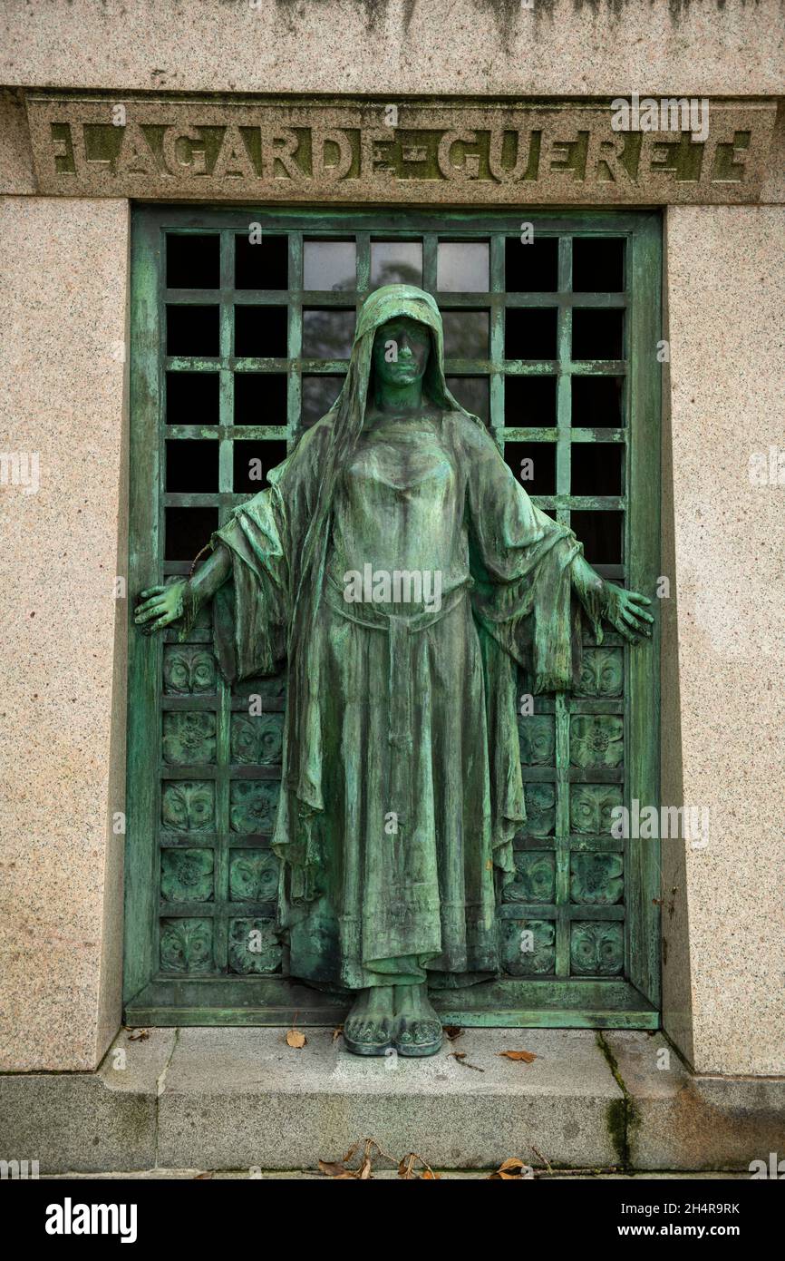 A bronze hooded female figure at the entrance of family vault. Pere Lachaise Cemetery in Paris, France. Stock Photo