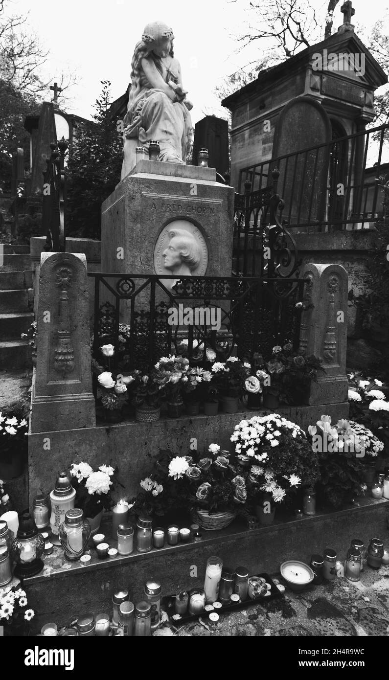 PARIS, FRANCE - NOVEMBER 1, 2021: The grave of composer Frederic Chopin in Pere Lachaise with flowers and candles in All Saints Day. Black white photo Stock Photo