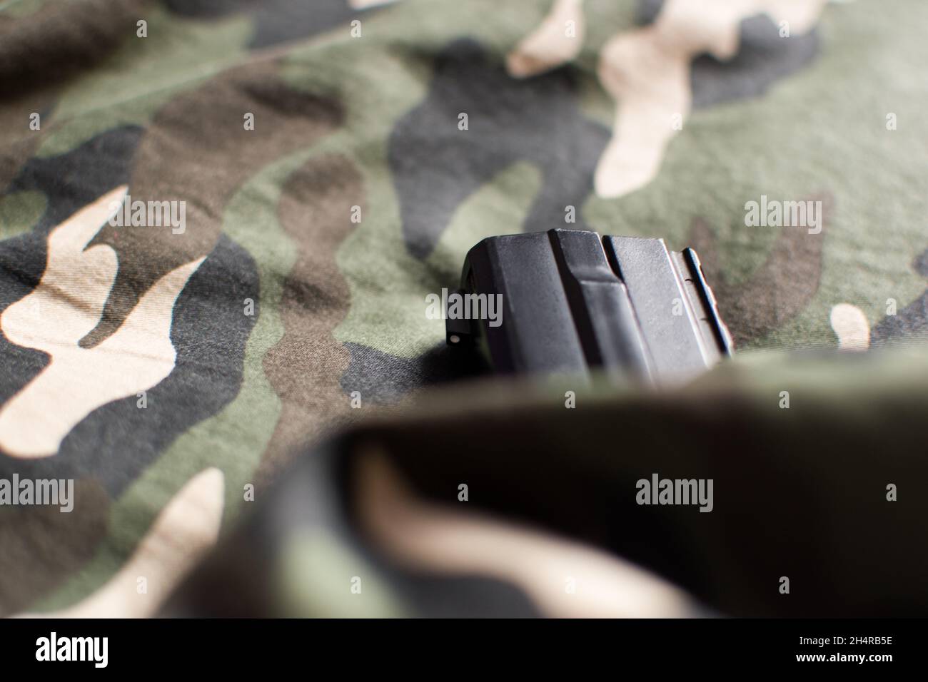 Hidden black handgun in military uniform Stock Photo
