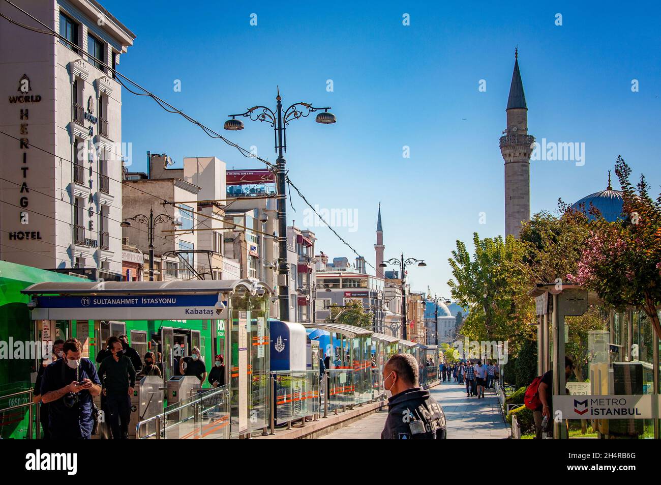 ISTANBUL, TURKEY. SEPTEMBER 26, 2021. Street view of the city, small shops and cafes, mosque's tower on the background, daylight Stock Photo