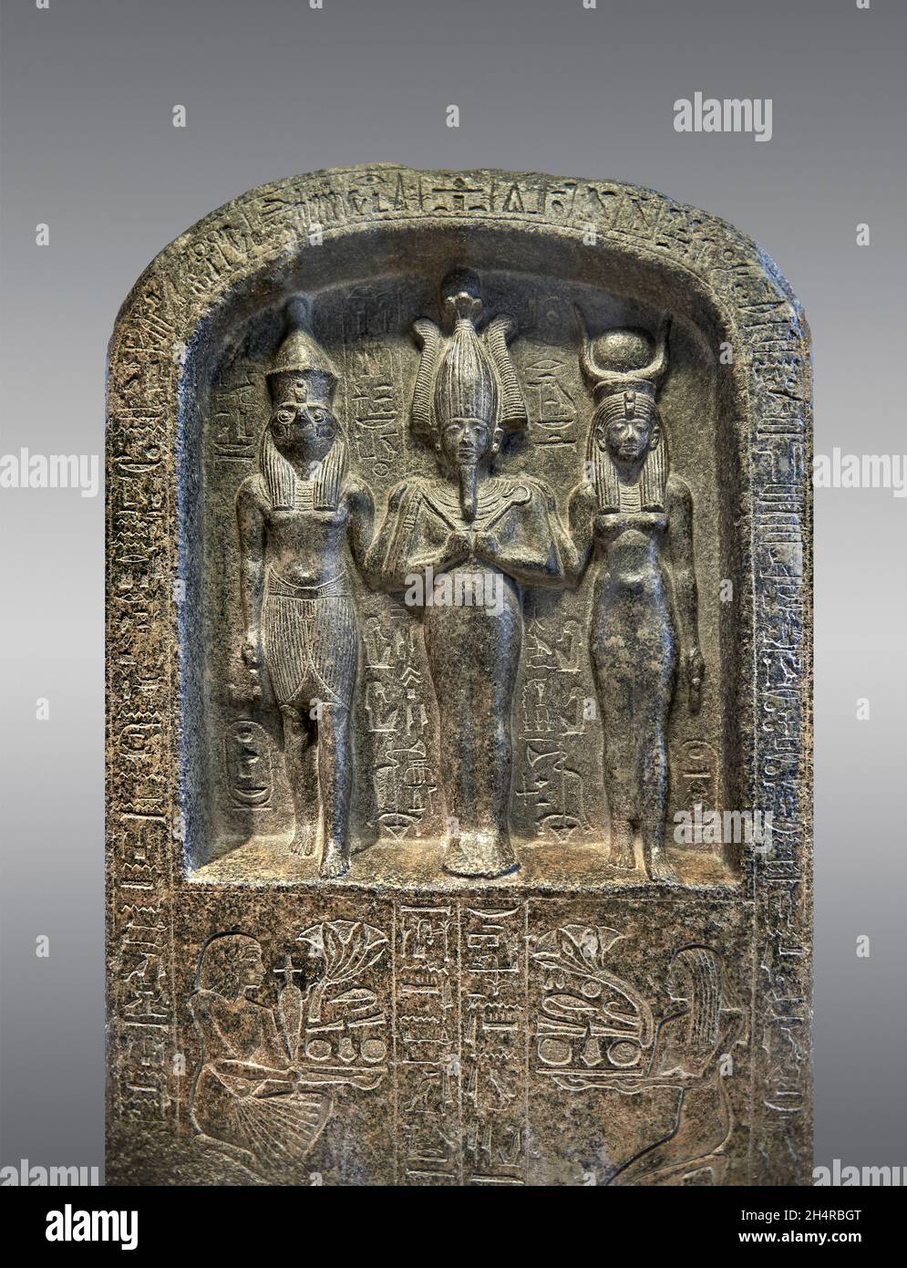 Ancient Egyptian stele of the patron gods of Abydos, Osiris, Horus and Isis, 1294-1279 BC, reign of Sethi 1st, 19th Dynasty, diorite. The Louvre Museu Stock Photo