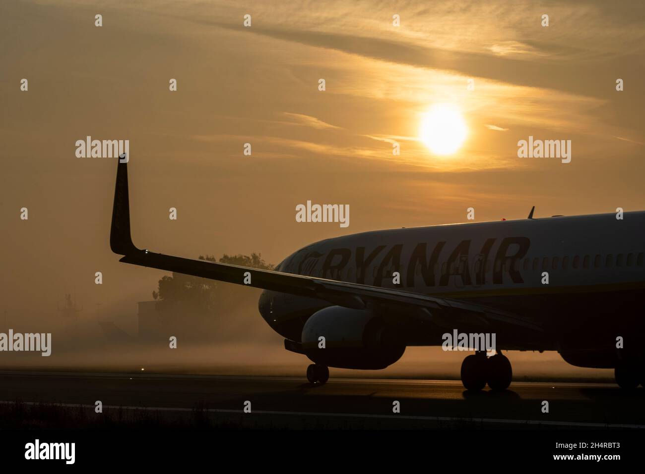 Ryanair Boeing 737 airliner jet plane taxiing out for an early morning flight at London Southend Airport, Essex, UK, in fog and mist at sunrise Stock Photo