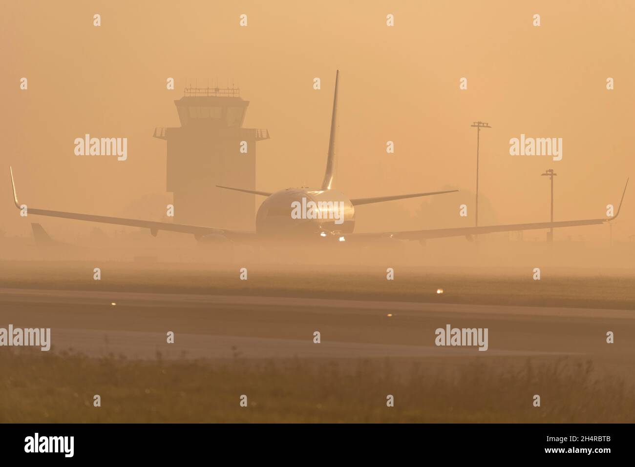 Ryanair Boeing 737 airliner jet plane taxiing out for an early morning flight at London Southend Airport, Essex, UK, in fog and mist at sunrise Stock Photo