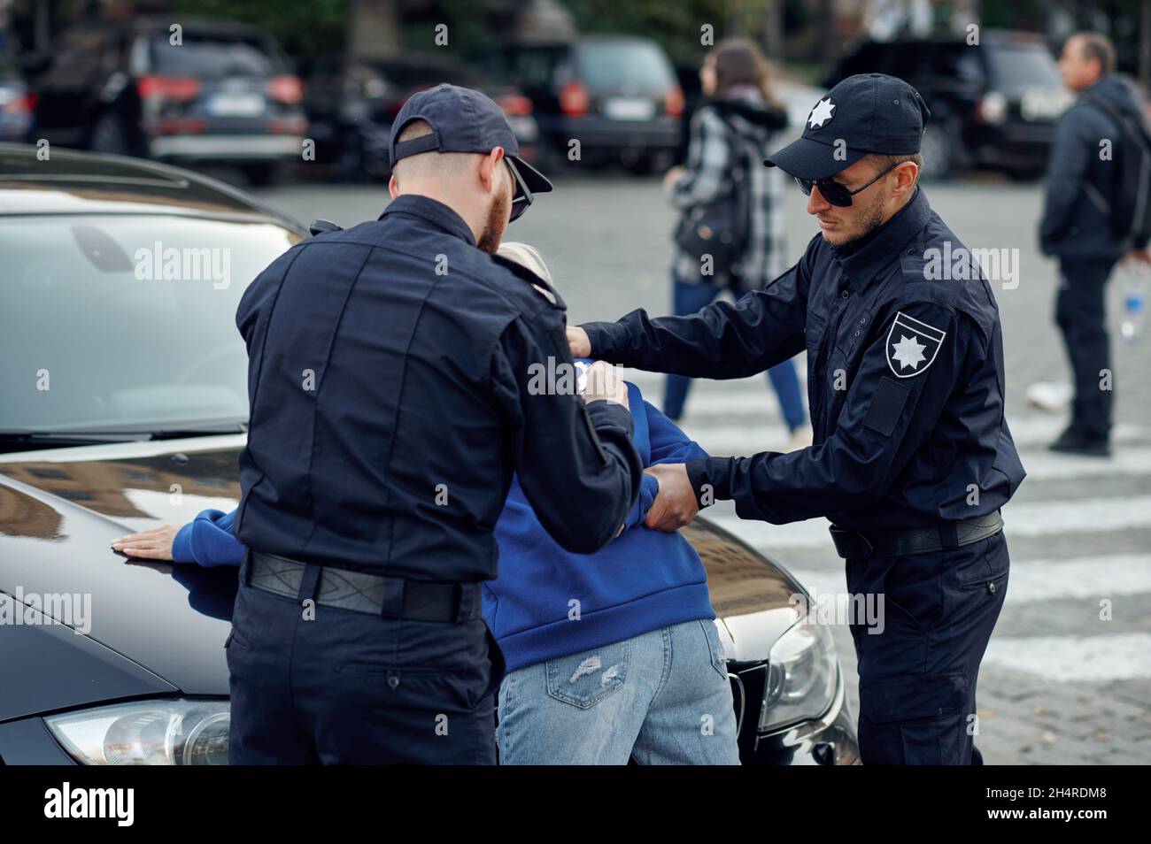 Two male police officers arrest female driver Stock Photo - Alamy