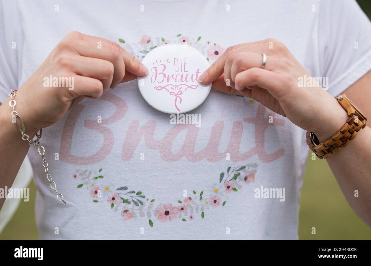 PRODUCTION - 02 August 2020, Baden-Wuerttemberg, Rottweil: A woman wears a T-shirt with the inscription 'Bride' and a button with the inscription 'The Bride' at her bachelor party. Photo: Silas Stein/dpa Stock Photo