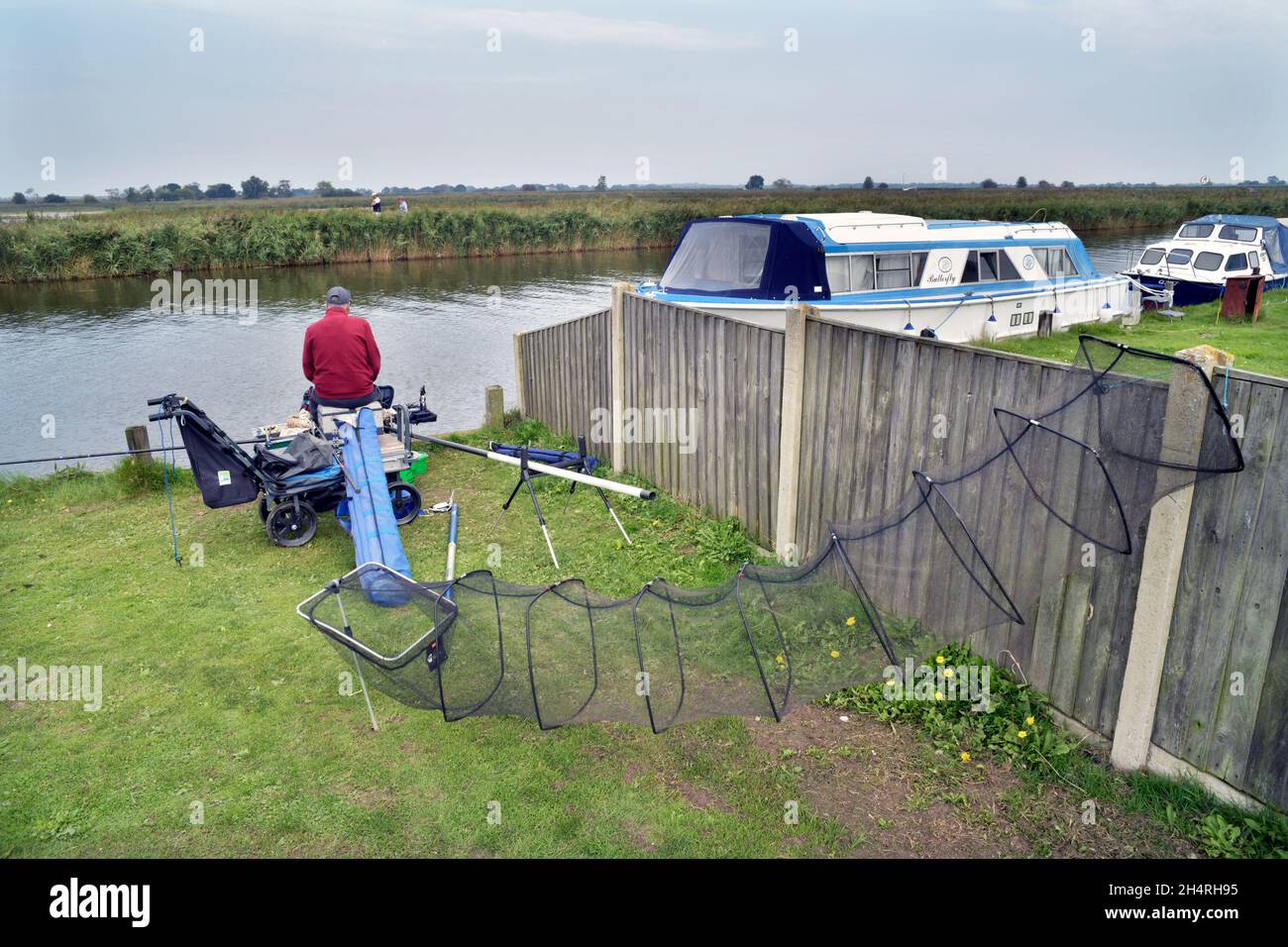pole fisherman and moored river cruisers river thurne martham norfolk england Stock Photo