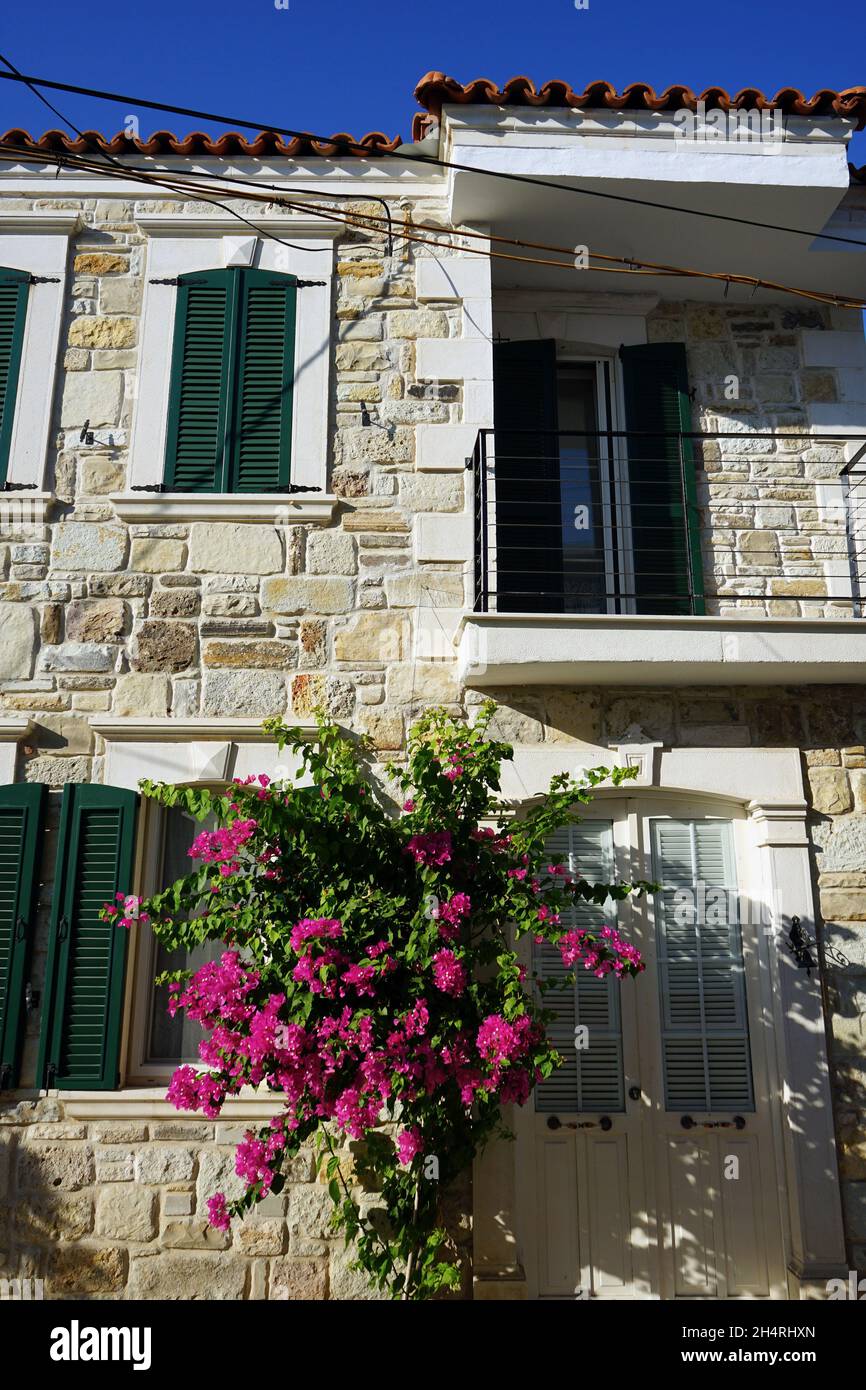 Facade of a stone house with purple flowers Stock Photo - Alamy