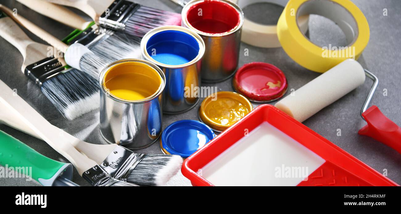 Paint cans and paintbrushes of different size for home decorating