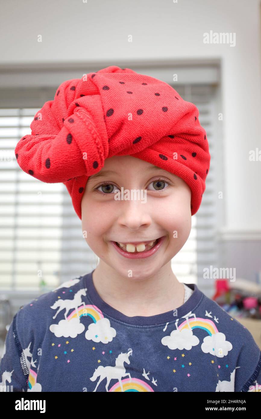 Happy young girl drying her hair with a hair turban. uk Stock Photo