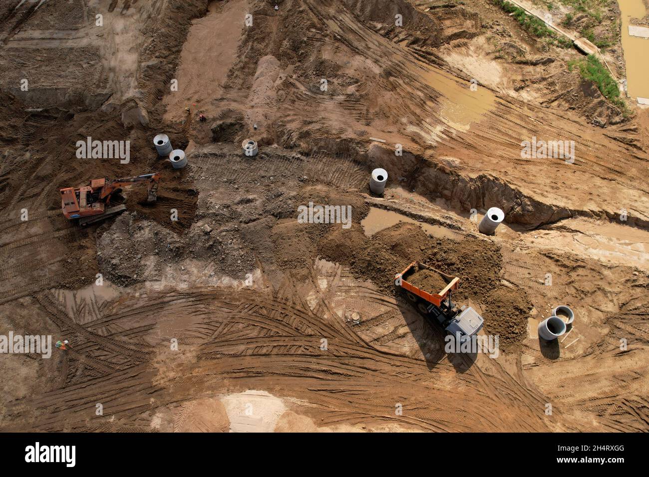 Laying of the concrete well ring and sewer pipes at construction site