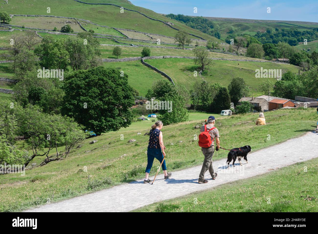 Walking Yorkshire, view in summer of a senior couple walking the Pennine Way in Malhamdale, an area of outstanding natural beauty in North Yorkshire Stock Photo