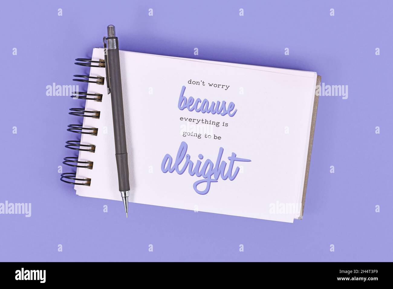 Text 'Don't worry because everything will be alright' in notebook on violet background Stock Photo