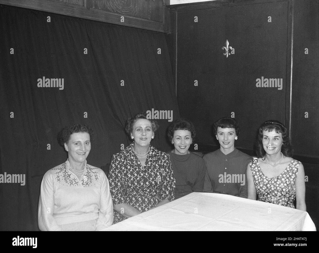 1950s, historical, ladies, old and young, of the Hepworth clothing company typing pool, sitting together at a company function at the Victoria Hotel, Leeds, England, UK, We see the female fashions of the era and three of them are wearing pearl necklaces, a popular evening wear item. Founded by Joseph Hepworth, Hepworths grew to become the UK's largest clothing manufacturer and retailer. It is now known as Next plc. Stock Photo