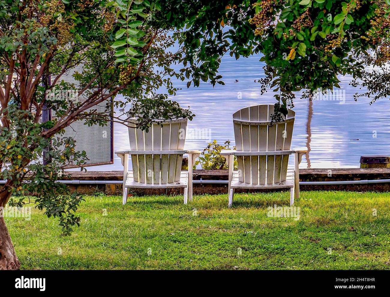 Two deck chairs on the lawn sloping down to a marina Stock Photo - Alamy