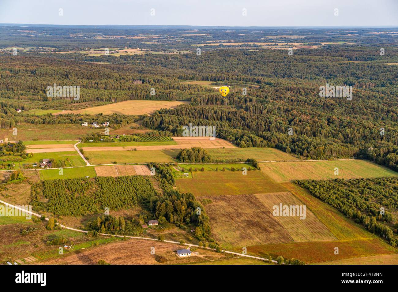 Vilnius, Lithuania - September 14, 2021: Vibrant yellow hot air balloon fly above Vilnius county in Lithuania Stock Photo