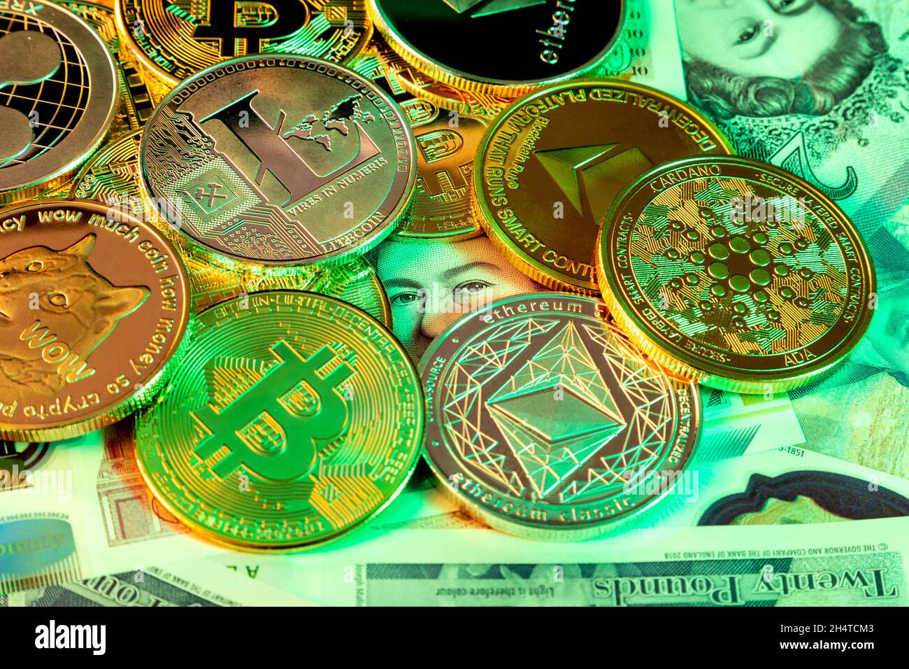 British pound notes covered by cryptocurrency coins, eyes peering through, threat to banks Stock Photo