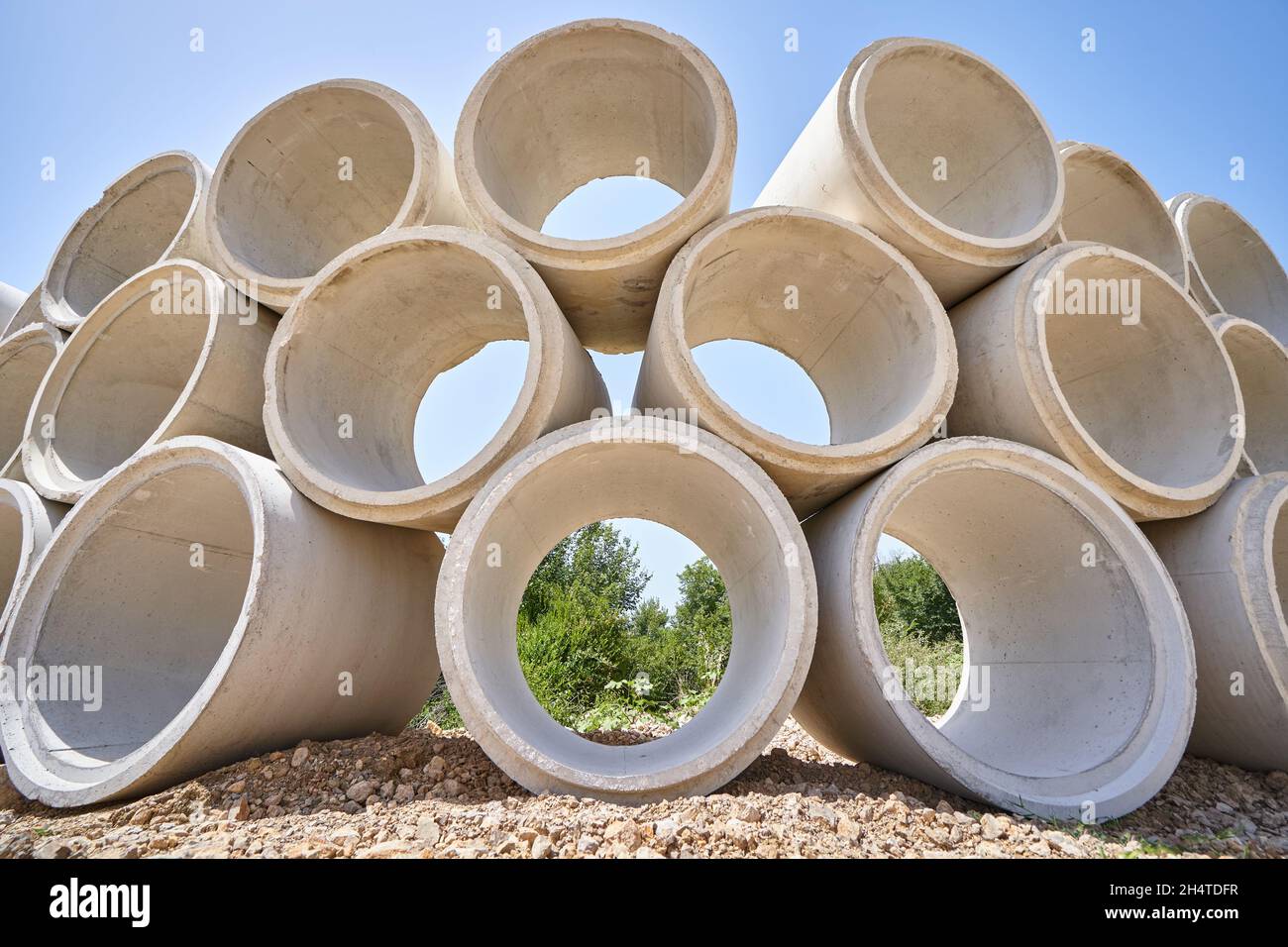 Stack of drainage concrete pipe for septic tanks and wells. Stock Photo